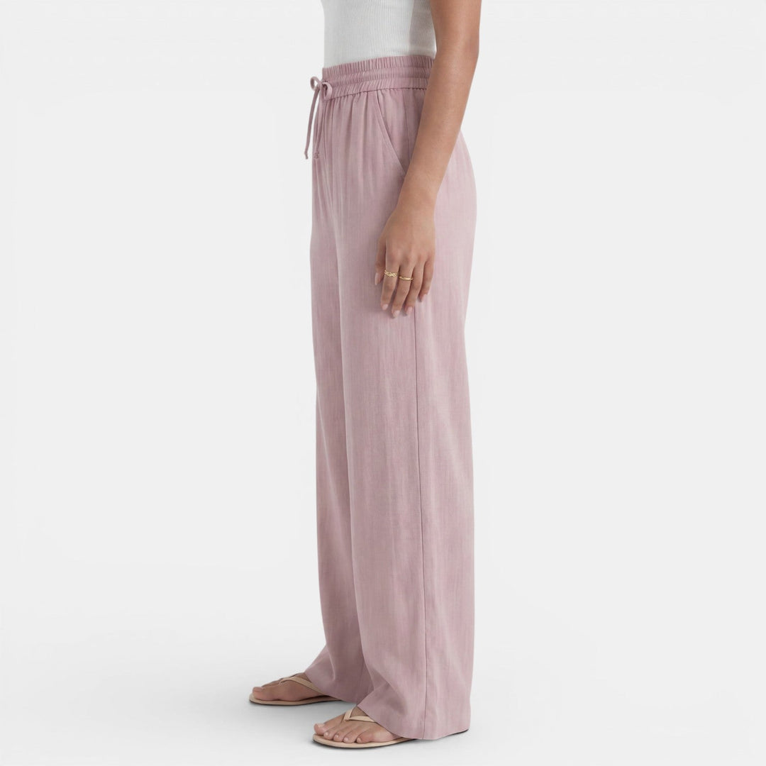 Mujer vistiendo pantalón ancho de lino beige, casual y fresco, perfecto para looks de verano.