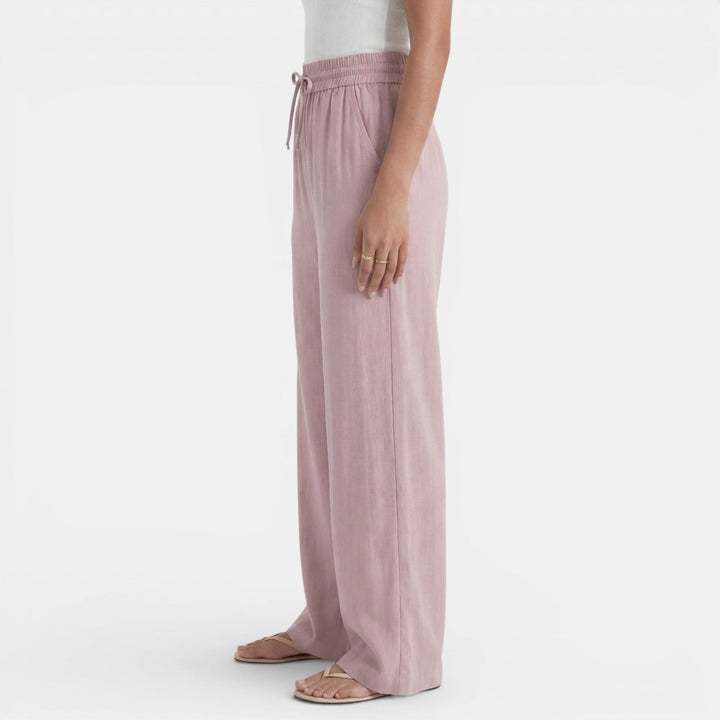 Mujer vistiendo pantalón ancho de lino beige, casual y fresco, perfecto para looks de verano.