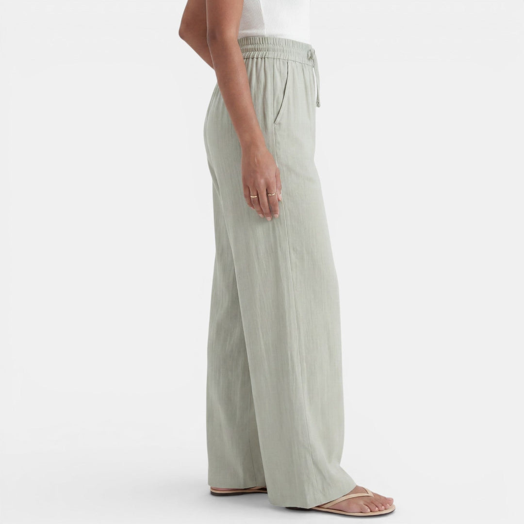 Detalle de la tela de lino del pantalón ancho para mujer, transpirable y cómodo para el verano.