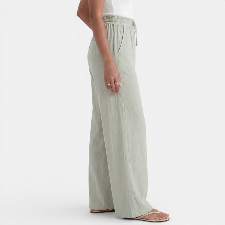 Detalle de la tela de lino del pantalón ancho para mujer, transpirable y cómodo para el verano.