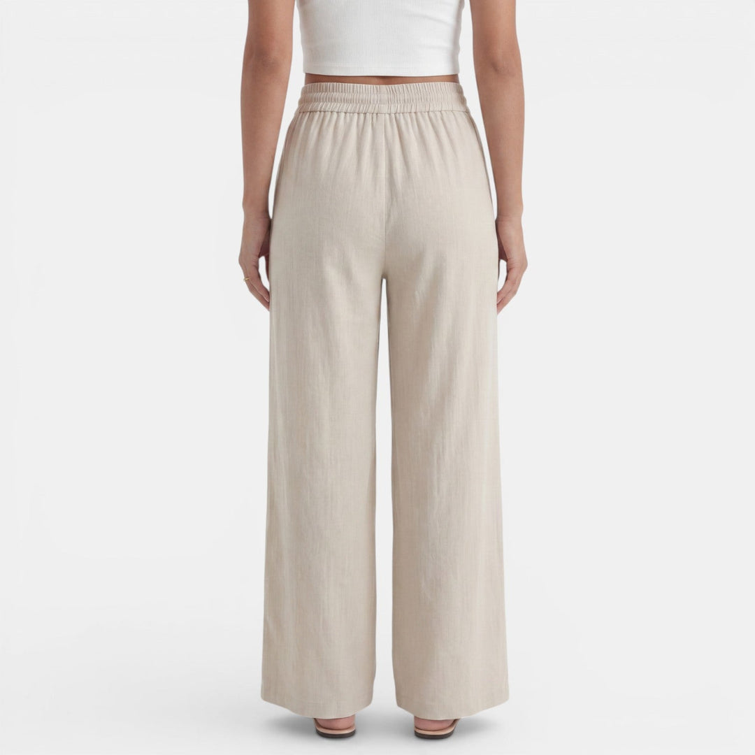 Mujer caminando con pantalón ancho de lino, movimiento fluido y fresco, ideal para el verano.