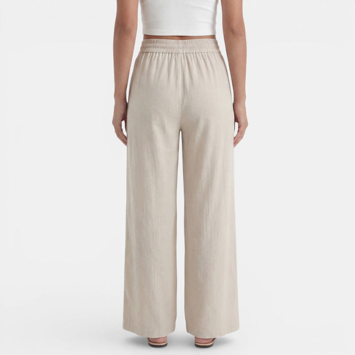 Mujer caminando con pantalón ancho de lino, movimiento fluido y fresco, ideal para el verano.