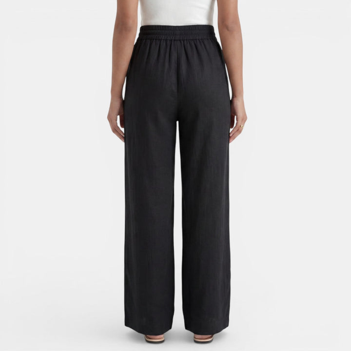 Vista trasera del pantalón ancho de lino para mujer, silueta holgada y casual, ideal para el verano.