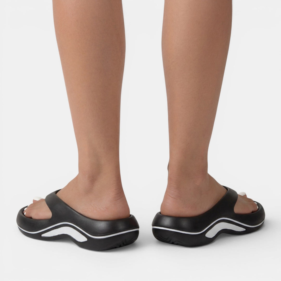 Mujer disfrutando la comodidad de las chanclas ortopédicas de verano, con amortiguación y soporte superior.