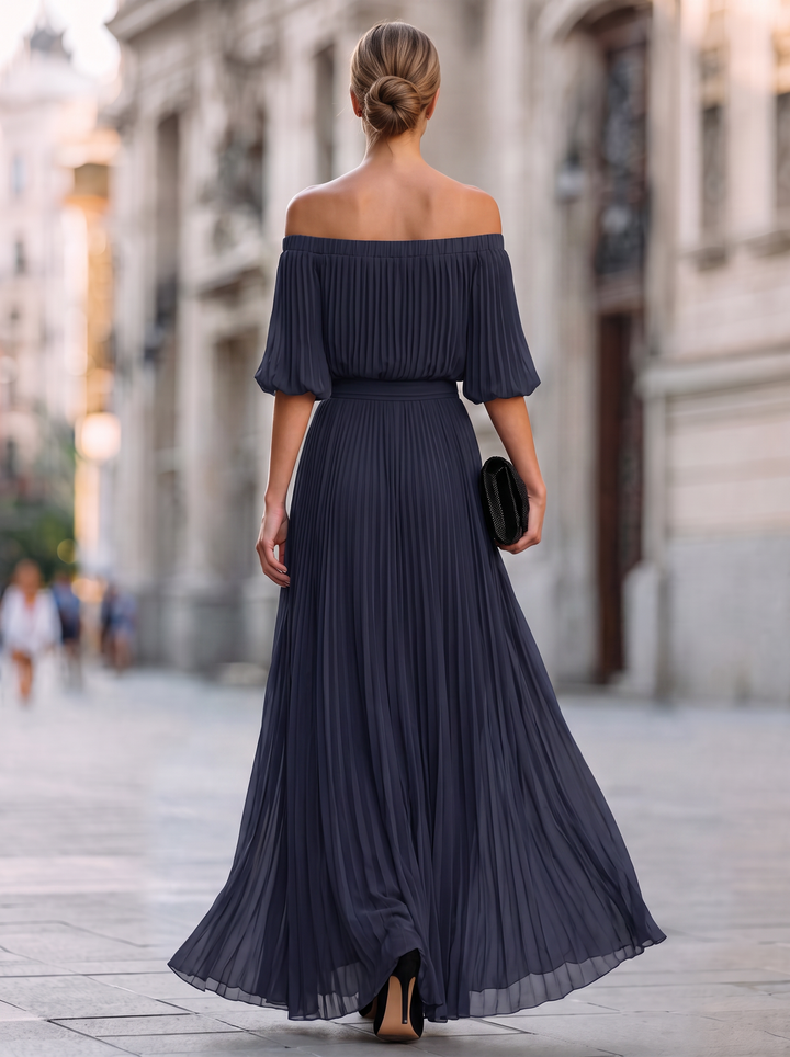 Modelo luciendo vestido largo formal para boda. Diseño elegante y sofisticado con falda plisada para mujer.