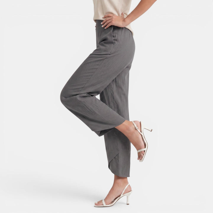 Moda casual: pantalón ancho de lino beige con pliegues, cintura alta, estilo relajado de mujer.