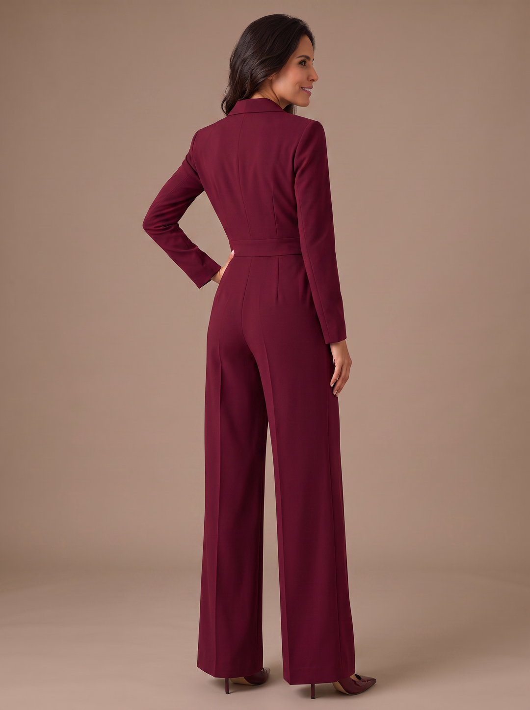 Mujer vistiendo mono elegante de manga larga, escote en V y pernera ancha. Moda femenina sofisticada.