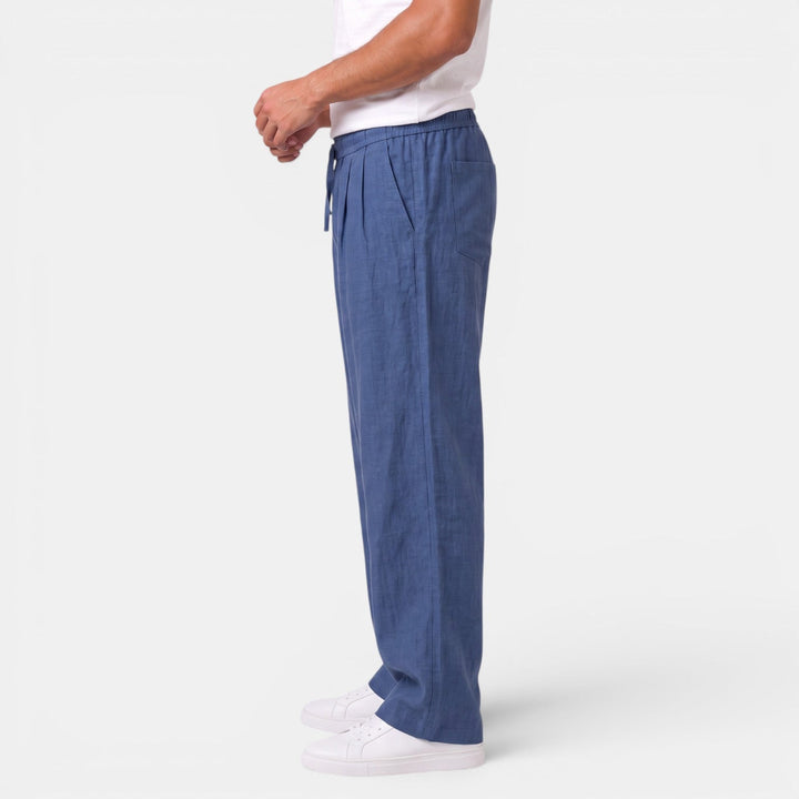 Hombre caminando con pantalón de lino recto, estilo casual y fresco, ideal para paseos de verano.