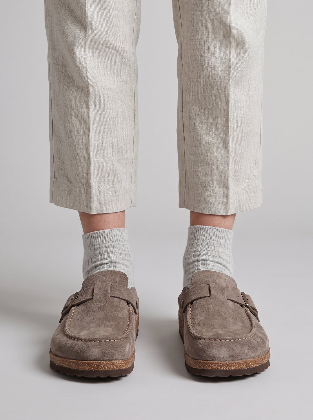 Primer plano de zueco de ante unisex. Detalle de textura suave, plantilla anatómica de corcho y hebilla.