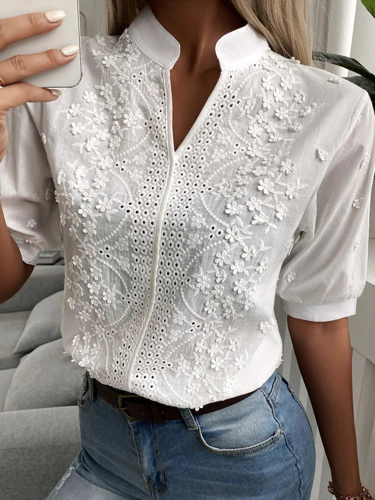 Blusa de mujer bordada, diseño de cuello alzado y escote en V. Perfecta para moda de verano sofisticada.