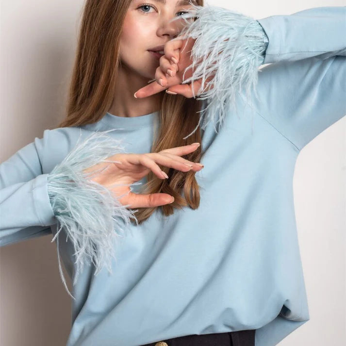 Elegante top de manga larga con plumas para mujer, perfecto para fiestas de invierno o noches especiales.