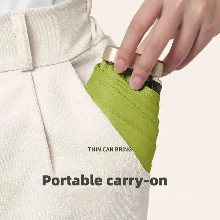 Mini paraguas plegable cerrado, muestra su tamaño portátil perfecto para bolsos.