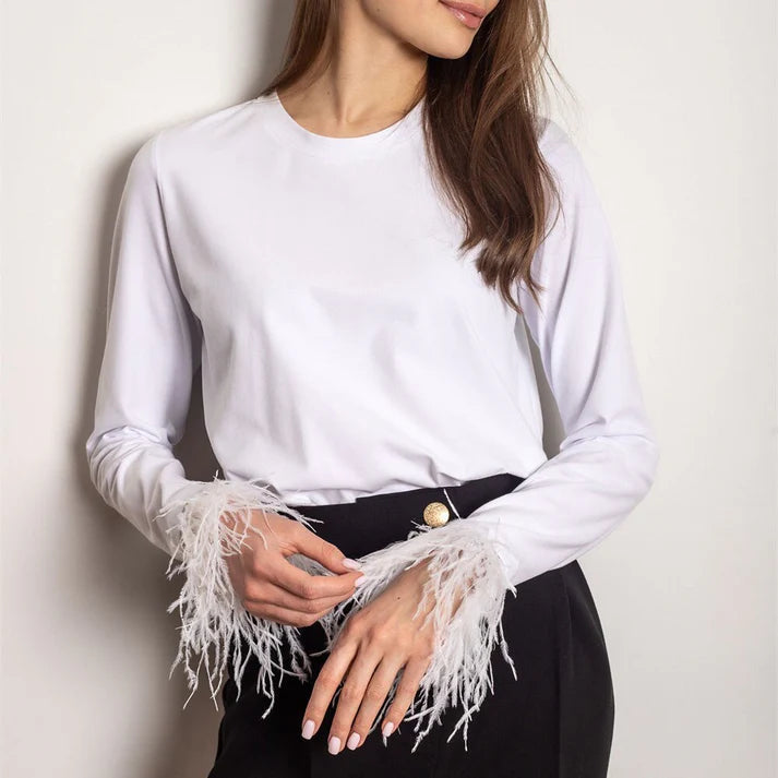 Top de mujer glamuroso con plumas y manga larga. Estilo moderno y chic para moda femenina de noche.