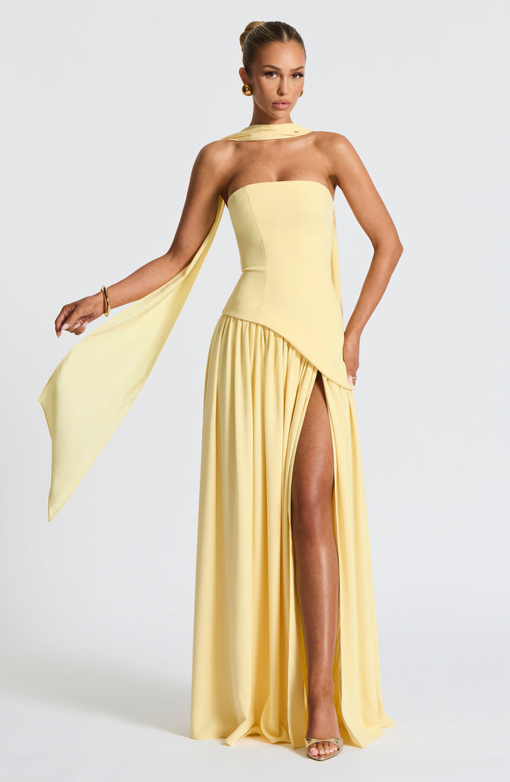 Mujer luciendo vestido maxi de noche, elegante, con abertura alta y cintura asimétrica. Moda femenina.