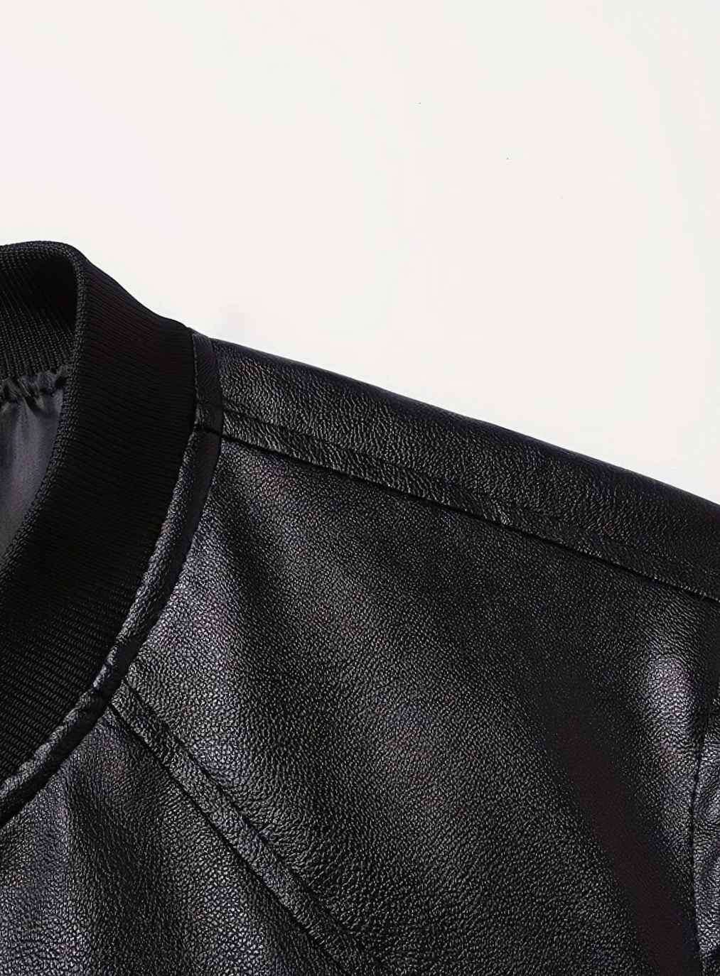 Cazadora de hombre negra, piel sintética, estilo bomber, corte ajustado, con cremallera.