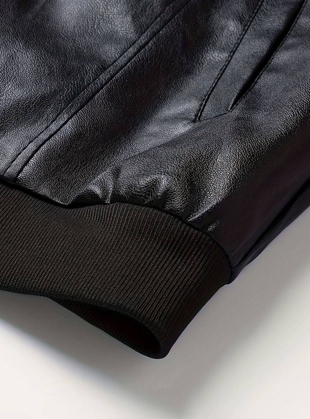 Cazadora masculina bomber negra, piel sintética de calidad, corte slim fit con cremallera.