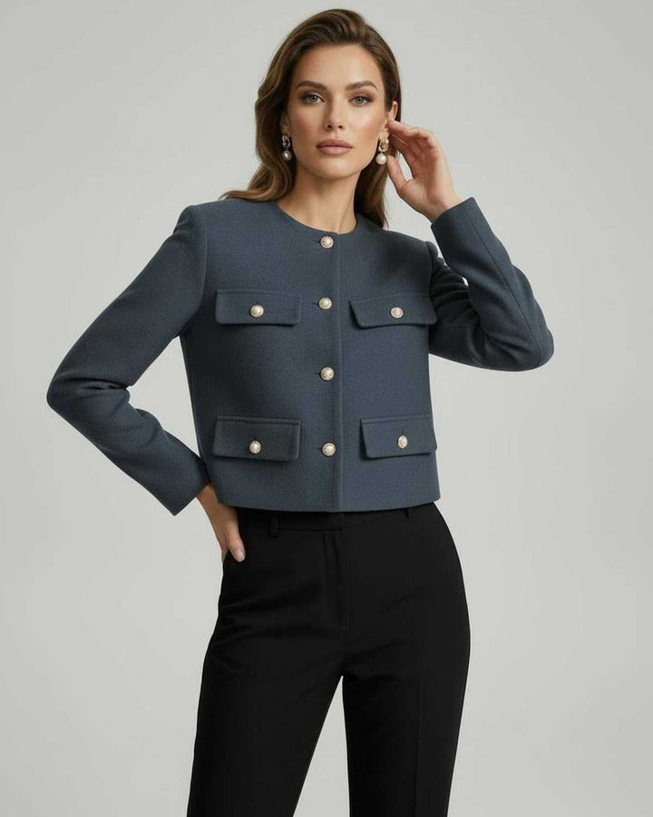 Chaqueta negra de mujer con diseño clásico, cuello y botones dorados. Prenda de vestir chic y moderna.