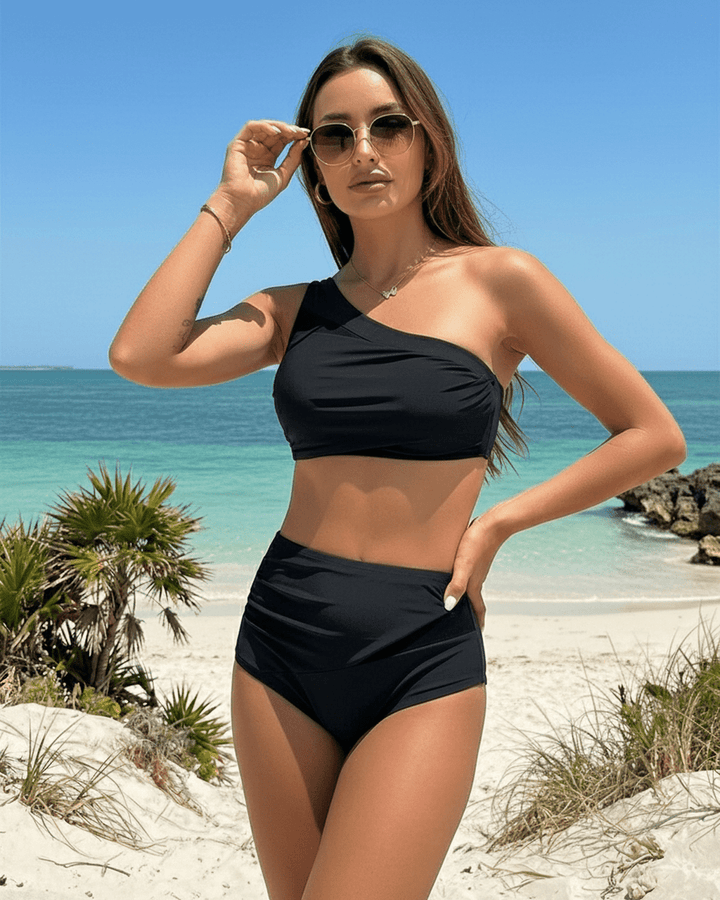 Bañador asimétrico de dos piezas negro para mujer, con diseño moderno y cintura alta. Ideal para el sol.