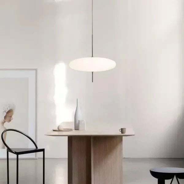 Detalle de lámpara colgante moderna de vidrio, con acabado metálico y diseño minimalista.
