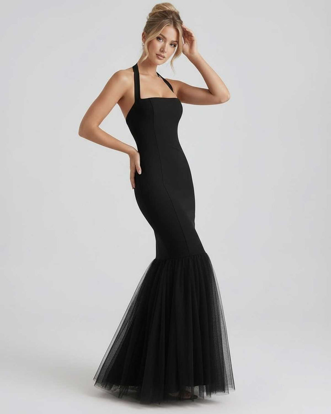 Vestido de noche negro de silueta sirena, con tul y cuello halter, para un look elegante y formal de mujer.