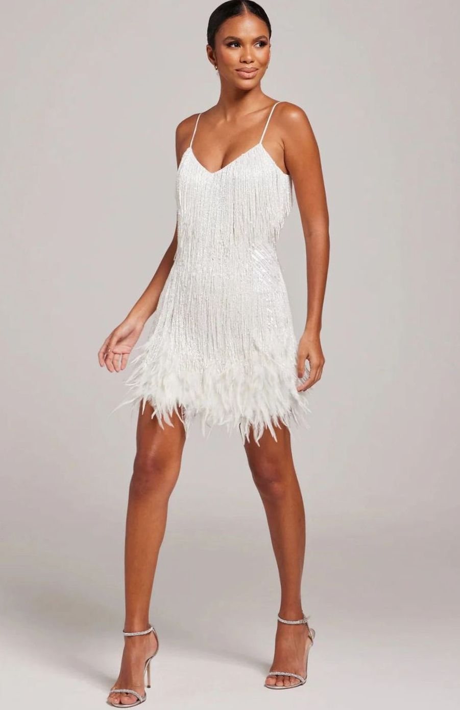 Mini vestido de noche con plumas y flecos brillantes. Estilo glamour para mujer.