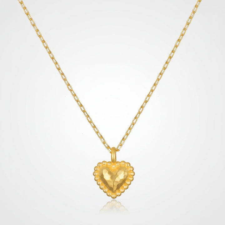 Collar elegante para mujer con colgante de corazón martillado bañado en oro. Joyería delicada y minimalista.