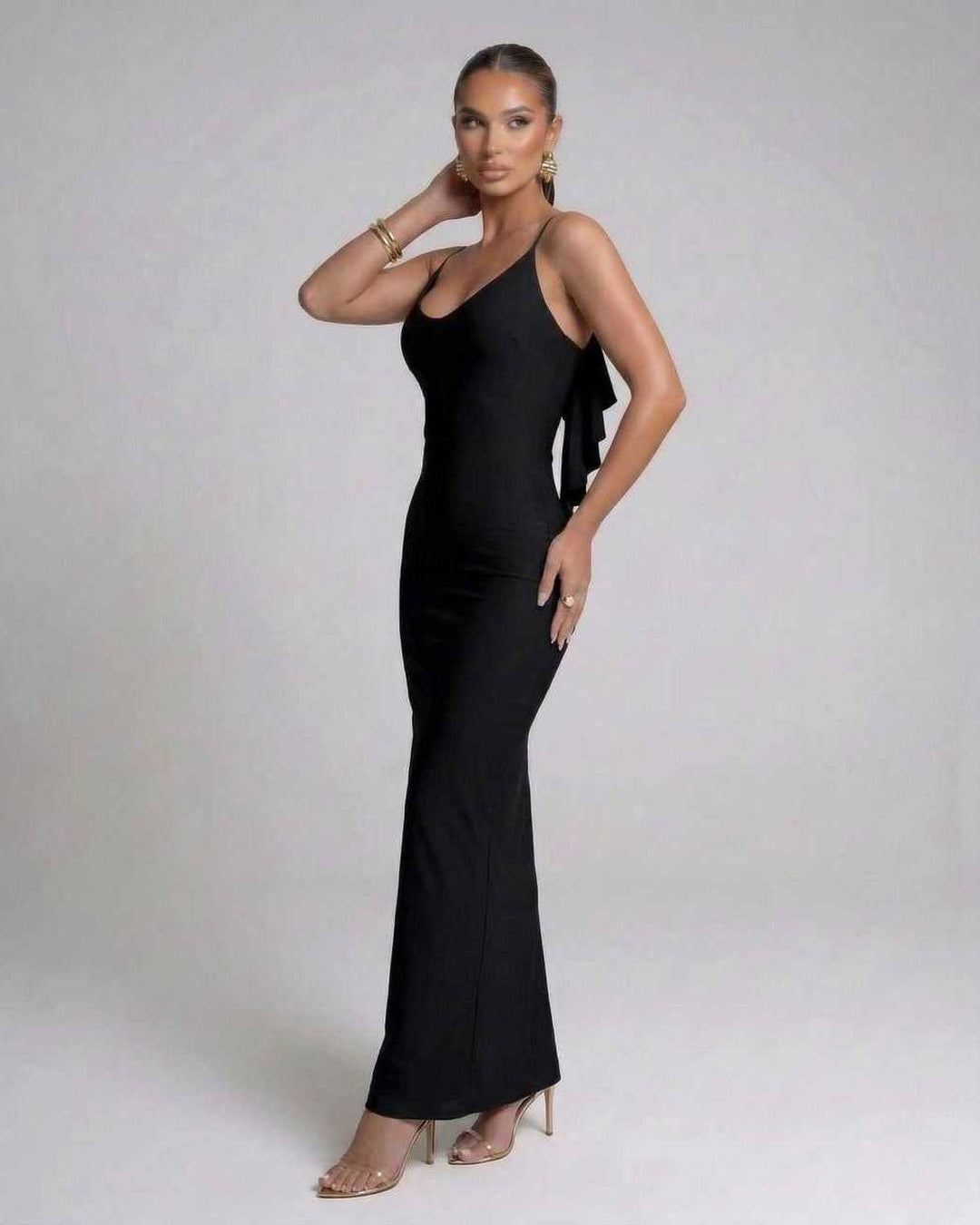 Vestido maxi negro de fiesta con tirantes finos, diseño sin espalda, elegante y moderno para noches inolvidables.