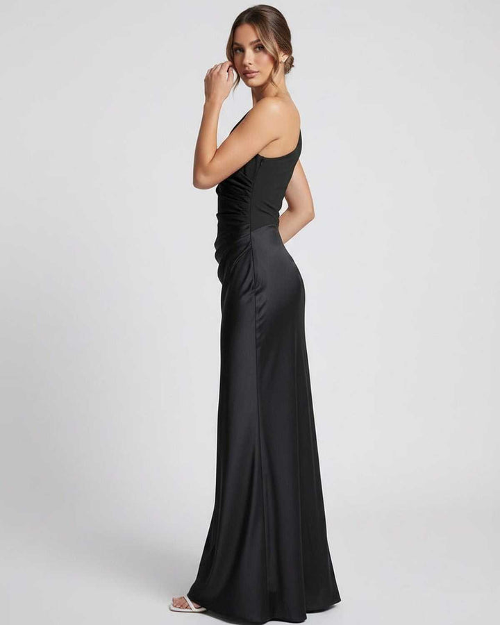 Modelo posando con vestido maxi negro formal de un hombro. Ideal para ocasiones especiales y cenas.