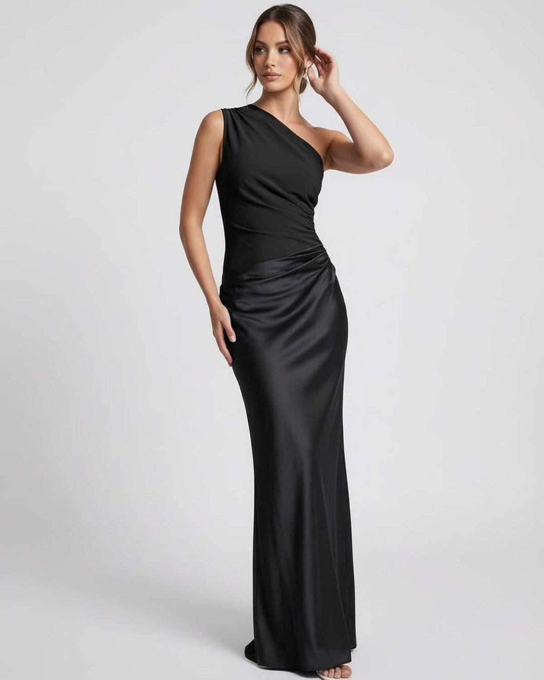 Vestido negro elegante de un hombro sobre maniquí. Diseño maxi largo, perfecto para eventos formales.