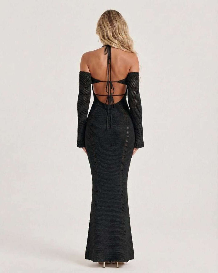 Elegante vestido de noche negro maxi, ajustado con escote halter y espalda descubierta. Moda formal para mujer.