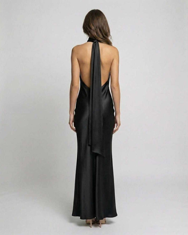Vista trasera de vestido maxi negro con escote halter y espalda descubierta, ideal para noche y celebraciones.