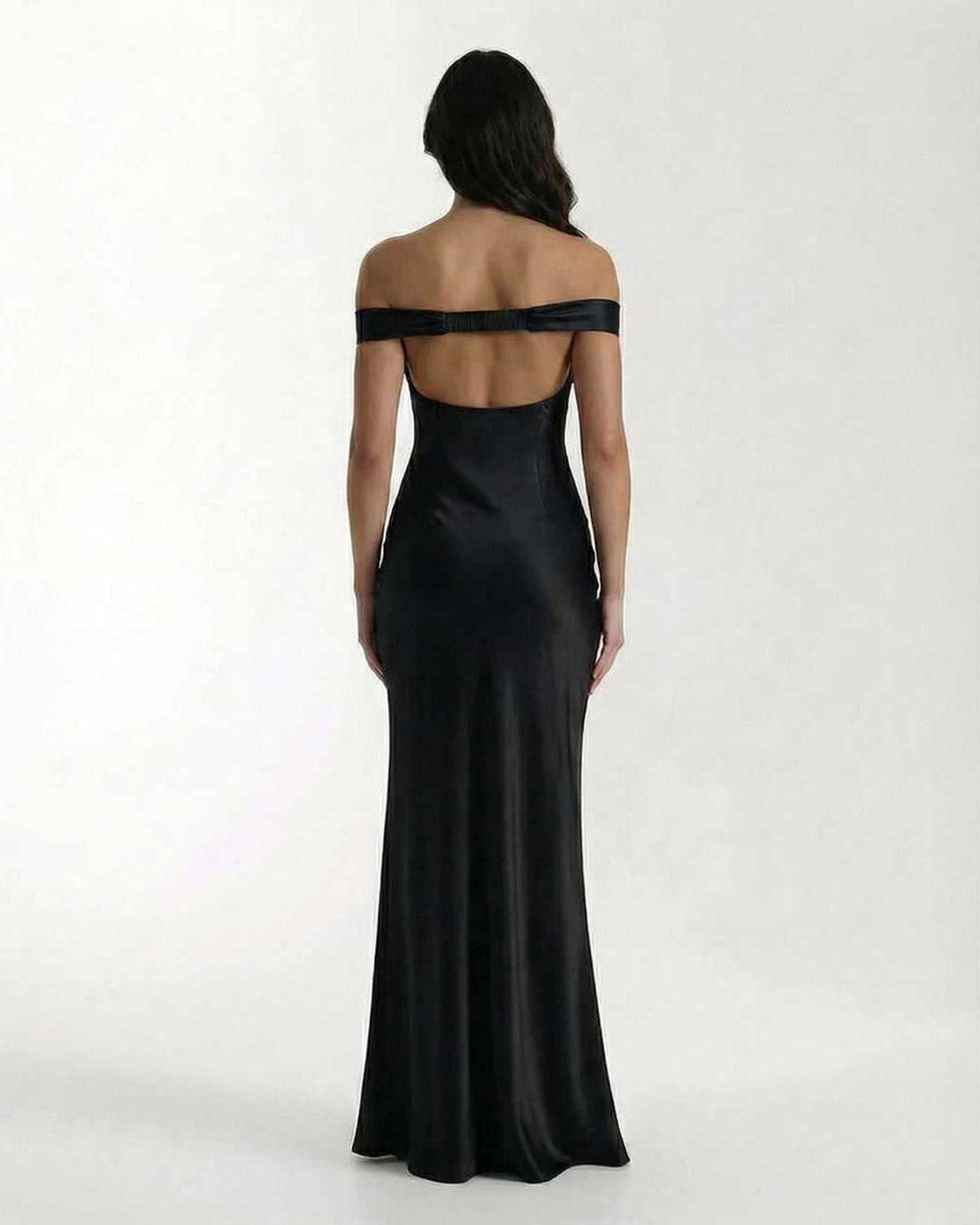 Sofisticado vestido de noche negro con silueta fluida y hombros descubiertos, perfecto invitada de boda.