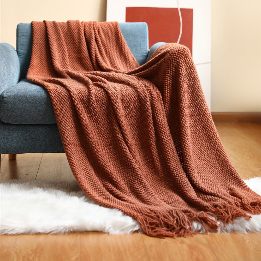 Textura suave de manta nórdica tejida en gris, detalle de punto, calidez y confort en textil hogar.