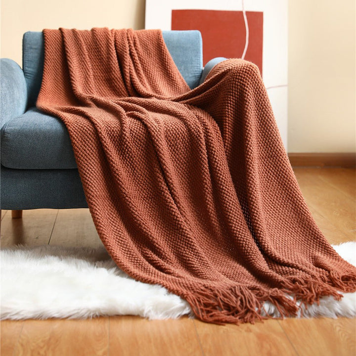 Textura suave de manta nórdica tejida en gris, detalle de punto, calidez y confort en textil hogar.