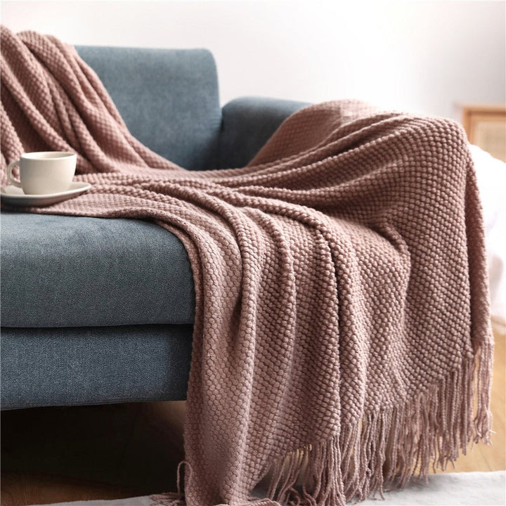 Manta nórdica tejida suave para sofá, ideal para momentos de relajación y calidez en el hogar.