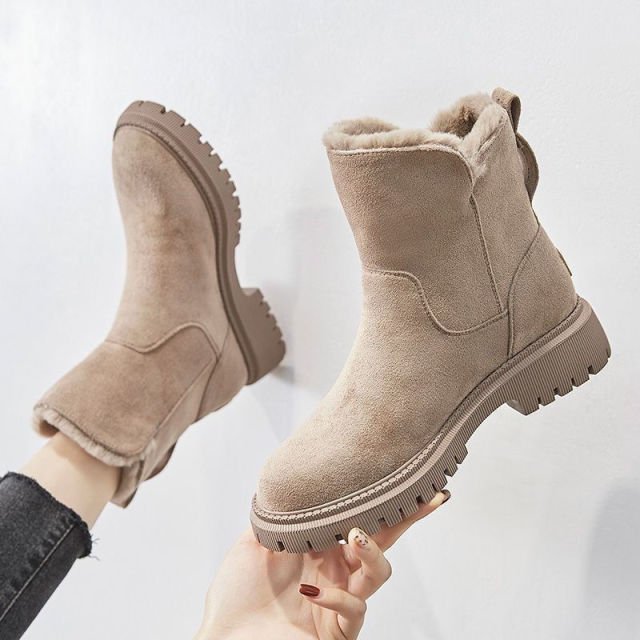 Mujer luciendo elegantes botas de invierno impermeables, combinando moda femenina y protección contra el frío.