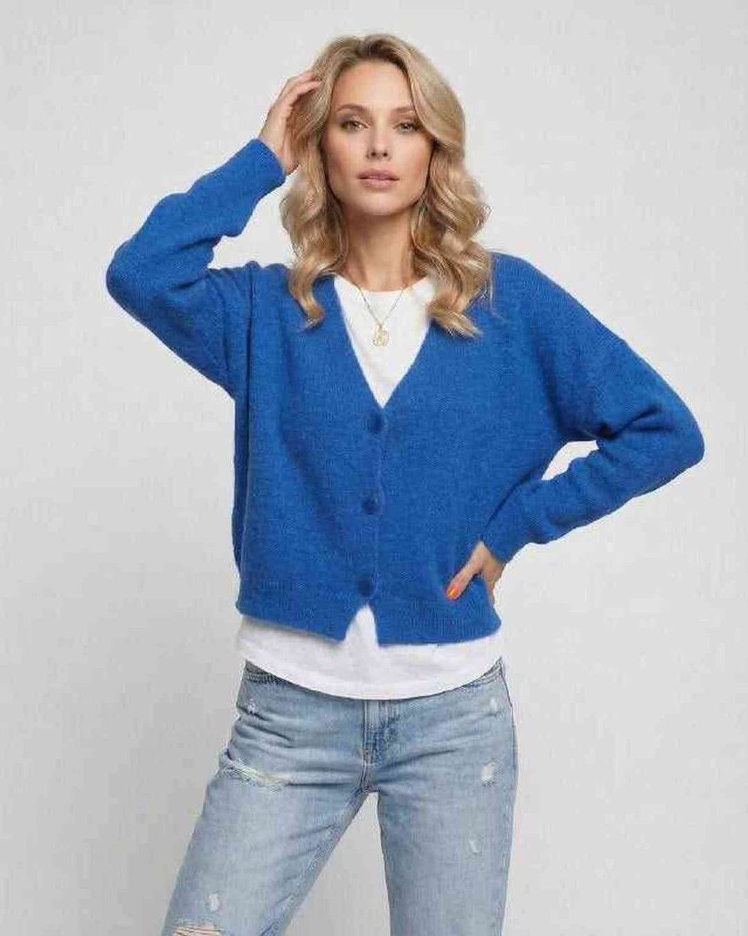 Mujer vistiendo cárdigan azul vibrante. Elegancia casual y confort para un estilo moderno de otoño/primavera.
