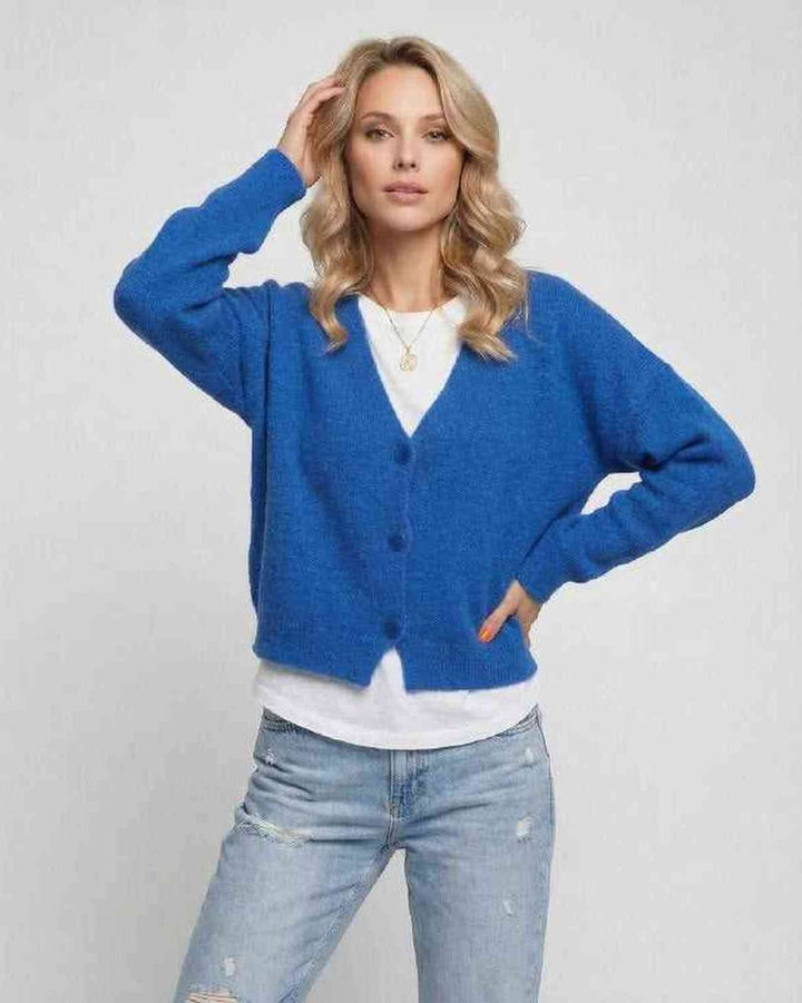 Mujer vistiendo cárdigan azul vibrante. Elegancia casual y confort para un estilo moderno de otoño/primavera.