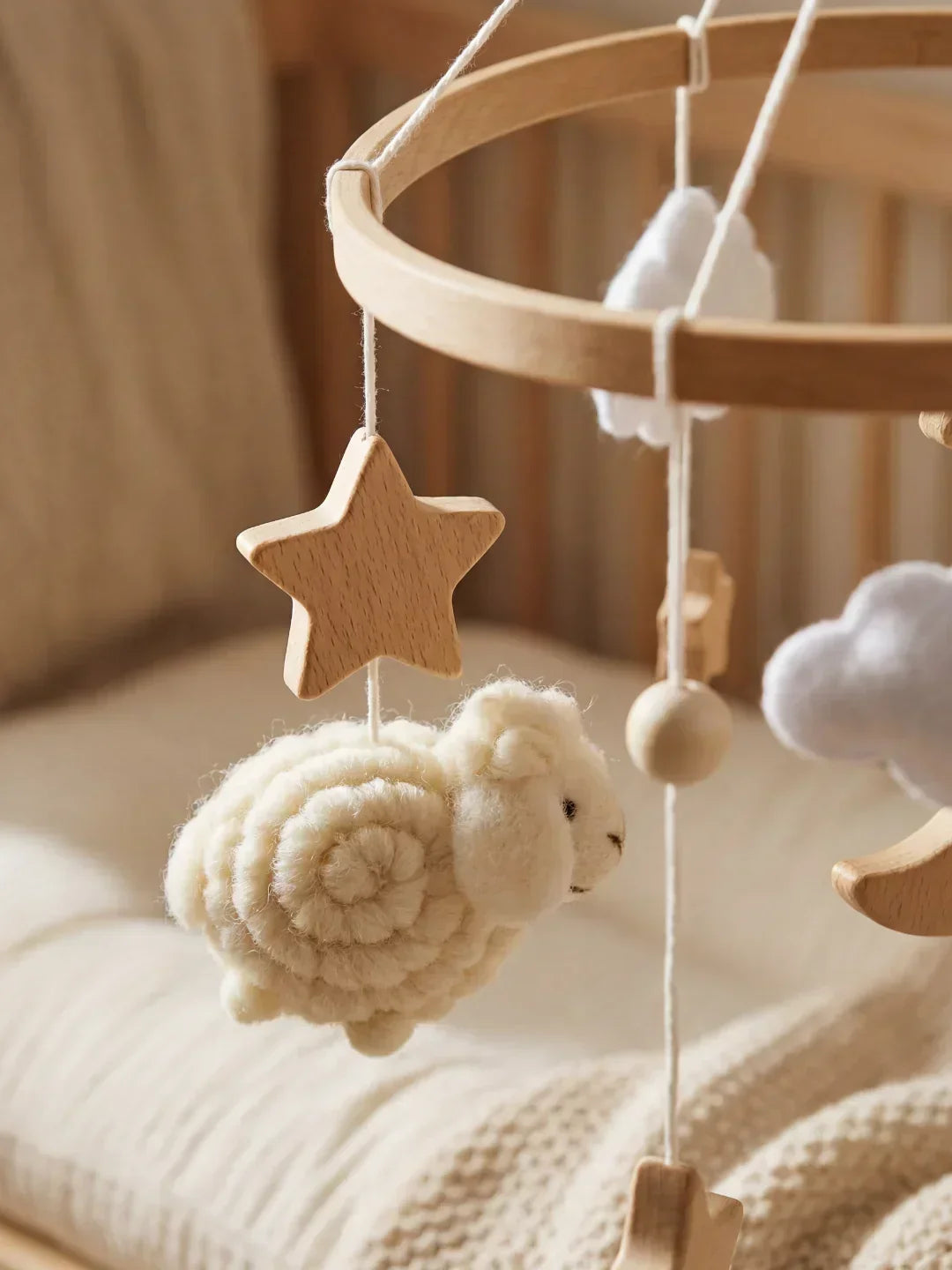 Móvil de cuna de madera con ovejas, armonizando con otros elementos de decoración infantil.