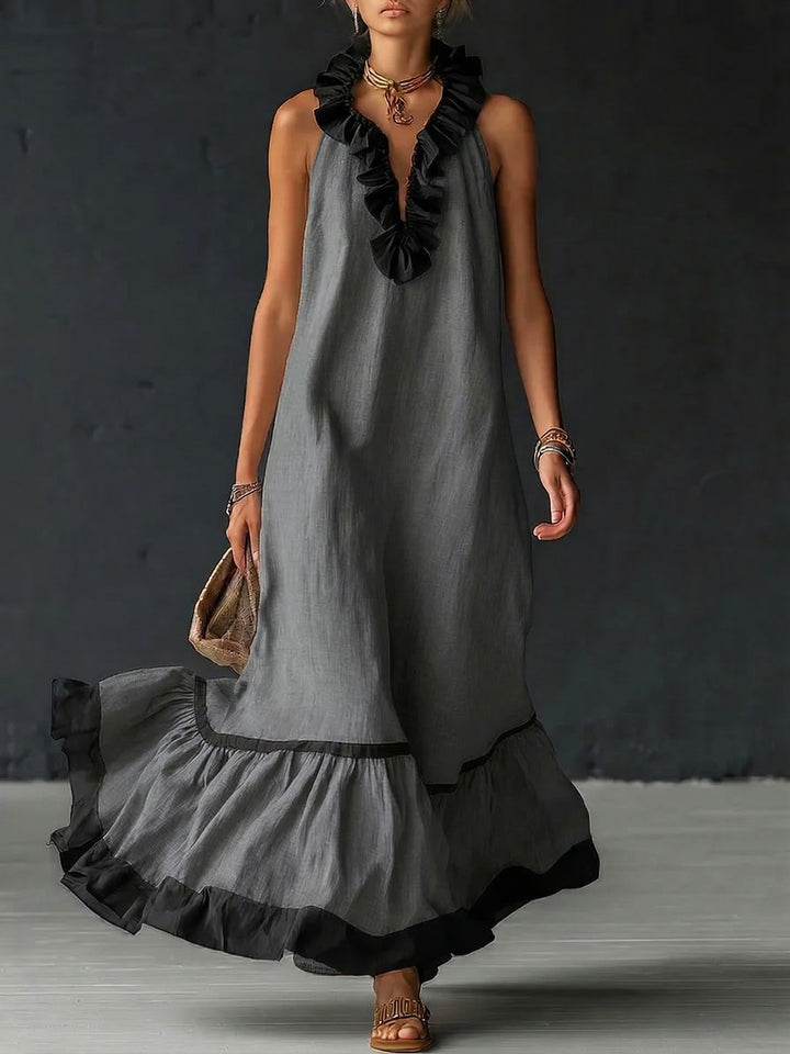 Vestido maxi boho bicolor con volantes, colgando, muestra diseño fluido de lino y algodón para mujer. Estilo chic.