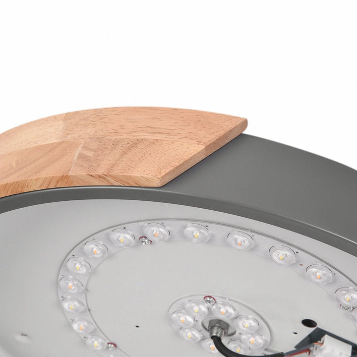 Montura LED de techo redonda con acento de madera natural, regulable, ilumina espacios modernos y acogedores.