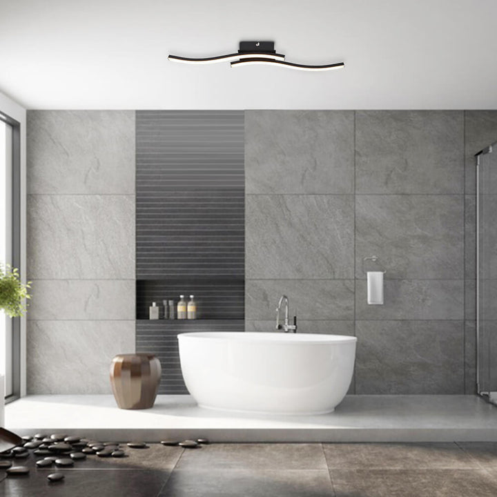 Luminaria LED moderna para baño, diseño curvo y regulable. Crea un ambiente cálido con iluminación semi empotrada.