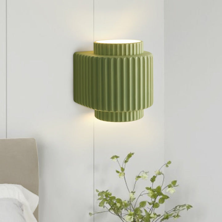Aplique de pared verde cilíndrico. Diseño de capas estilo nórdico, perfecto para decoración interior contemporánea.