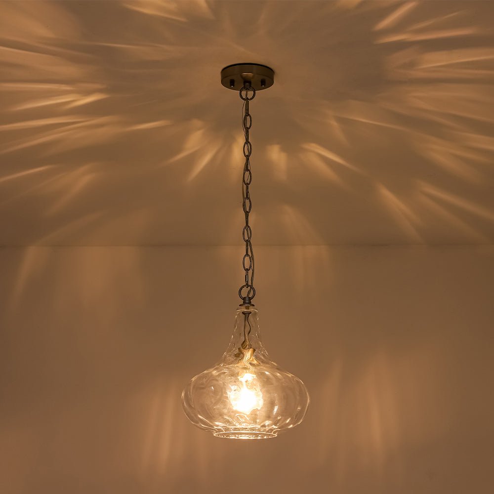 Lámpara escultórica de vidrio martillado en forma de gota, ideal para crear luz ambiente decorativa en el hogar.