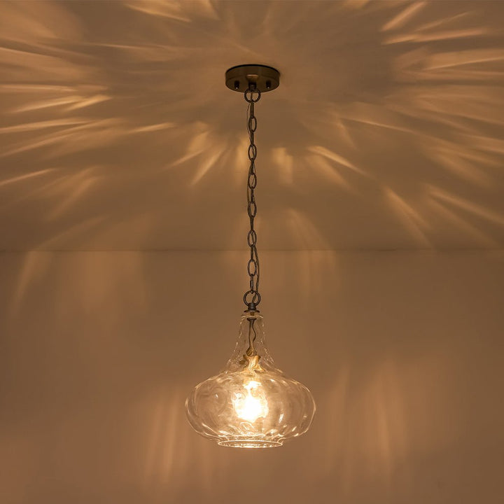 Lámpara escultórica de vidrio martillado en forma de gota, ideal para crear luz ambiente decorativa en el hogar.