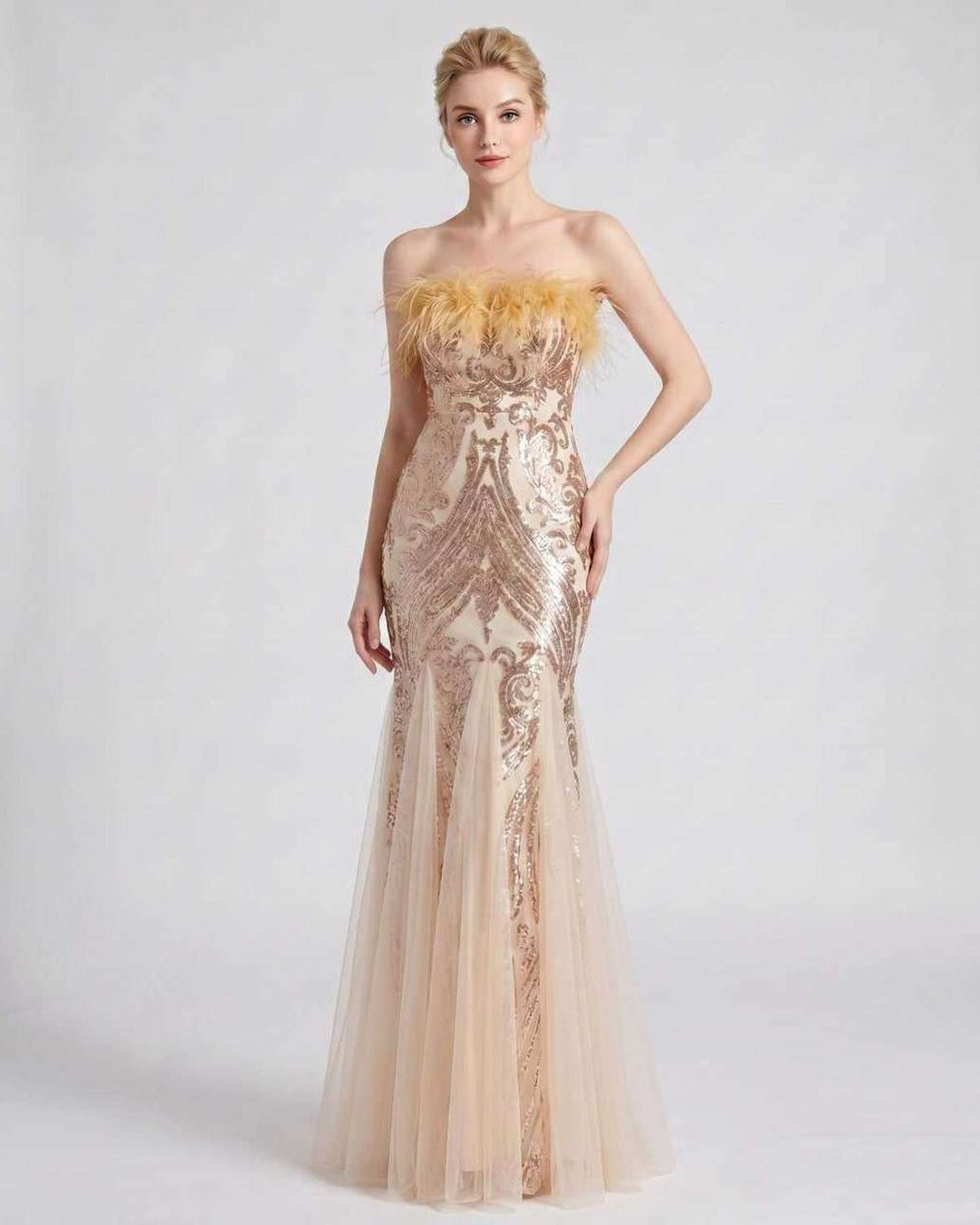 Vestido de gala con lentejuelas y plumas, hombros descubiertos. Estilo y sofisticación.