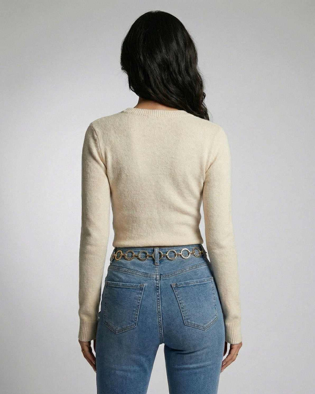 Elegante suéter blanco de mujer con detalle de nudo frontal, perfecto para un look casual de moda.