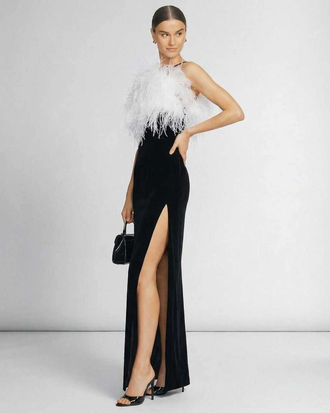 Magnífico vestido maxi celeste con apliques de plumas en el escote halter, ideal para eventos de gala.