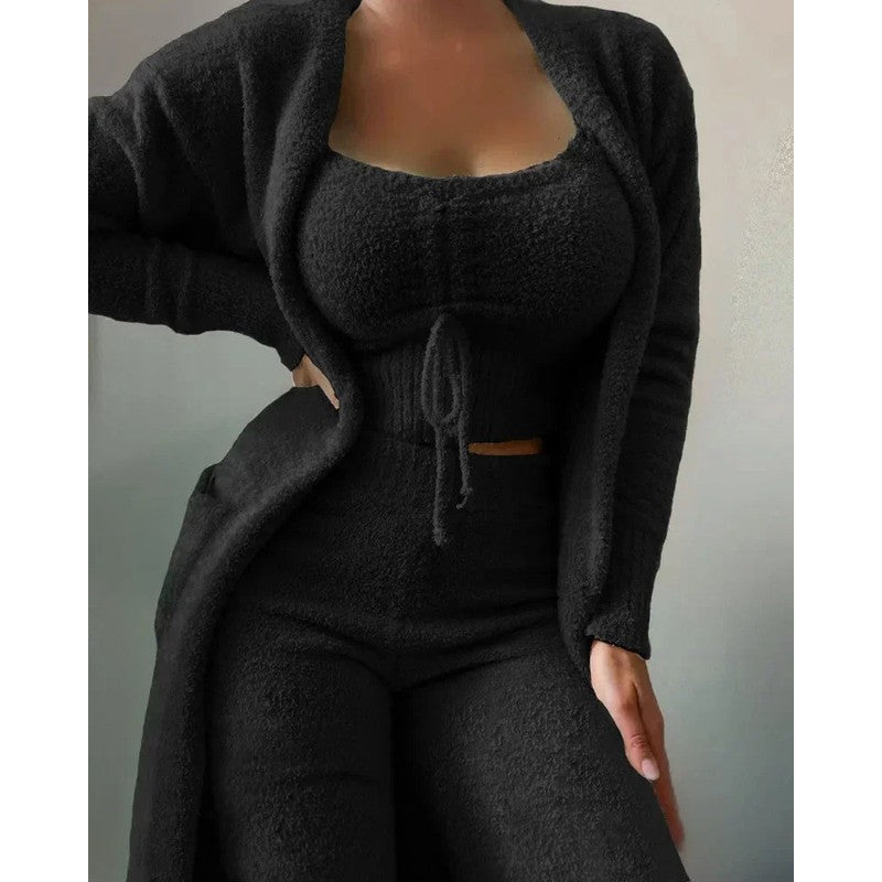 Modelo luciendo pijama mujer de lujo 3 piezas: top, pantalón y cárdigan. Conjunto de ropa de casa.