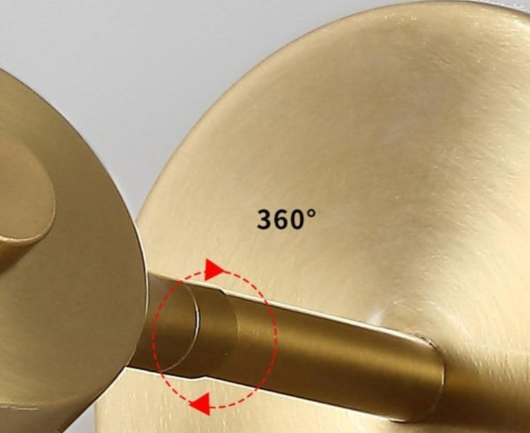 Lámpara de pared de diseño interior, acabada en latón dorado. Luz ajustable para ambientes modernos.